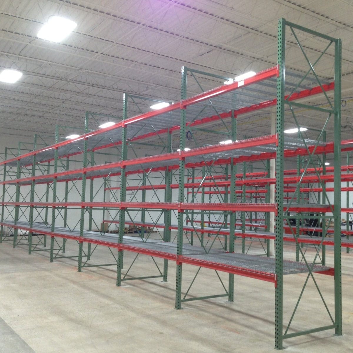 Orange and Green speedrack teardrop pallet racking in warehouse with wire decks